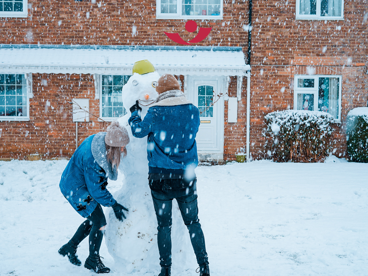 Paar baut Schneemann
