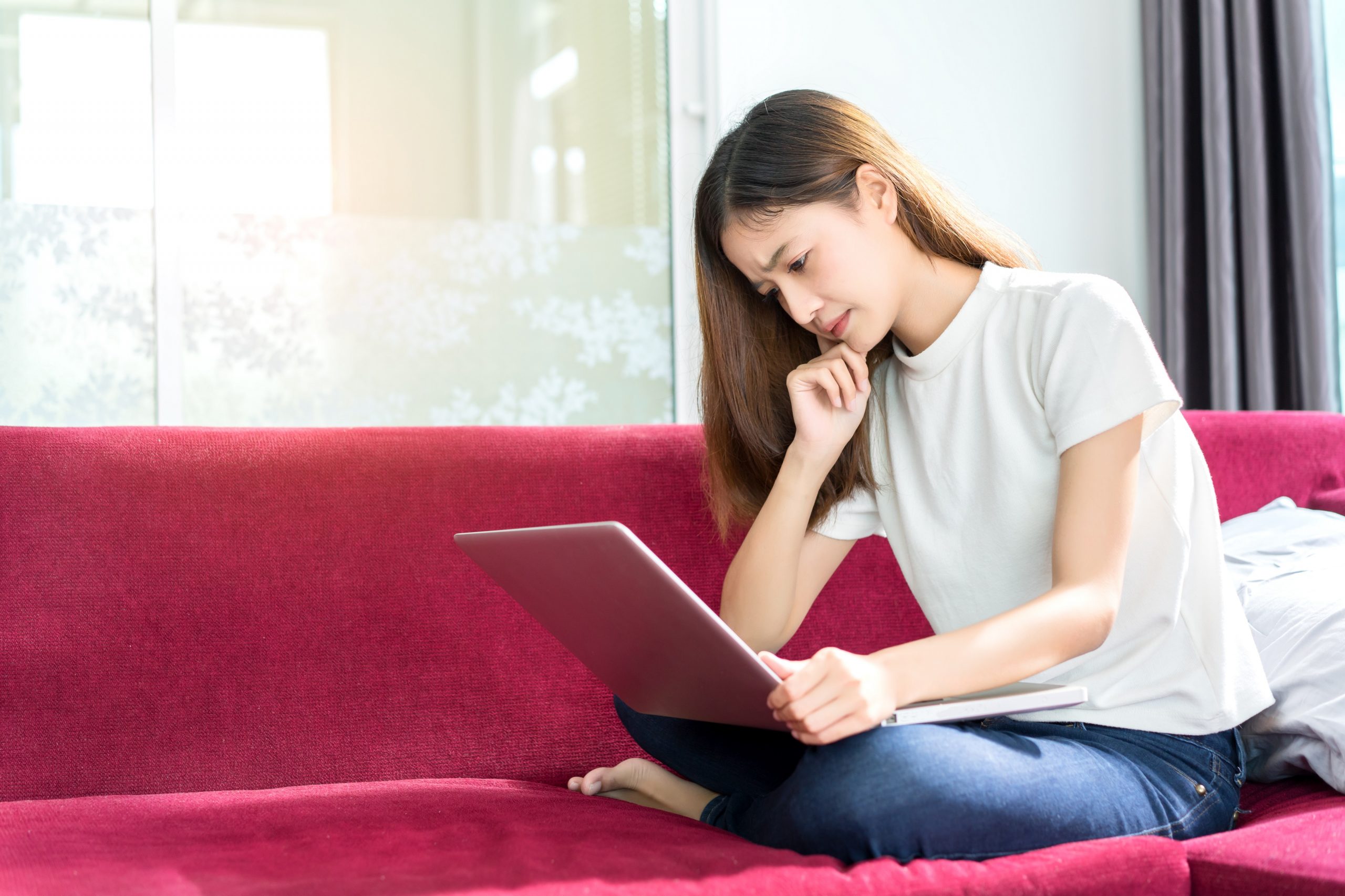 Frau auf Couch mit Laptop