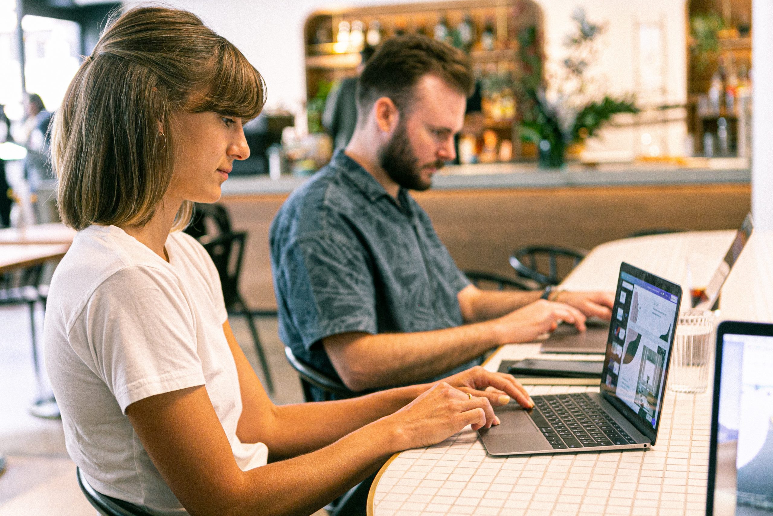 Frau und Mann an Laptops