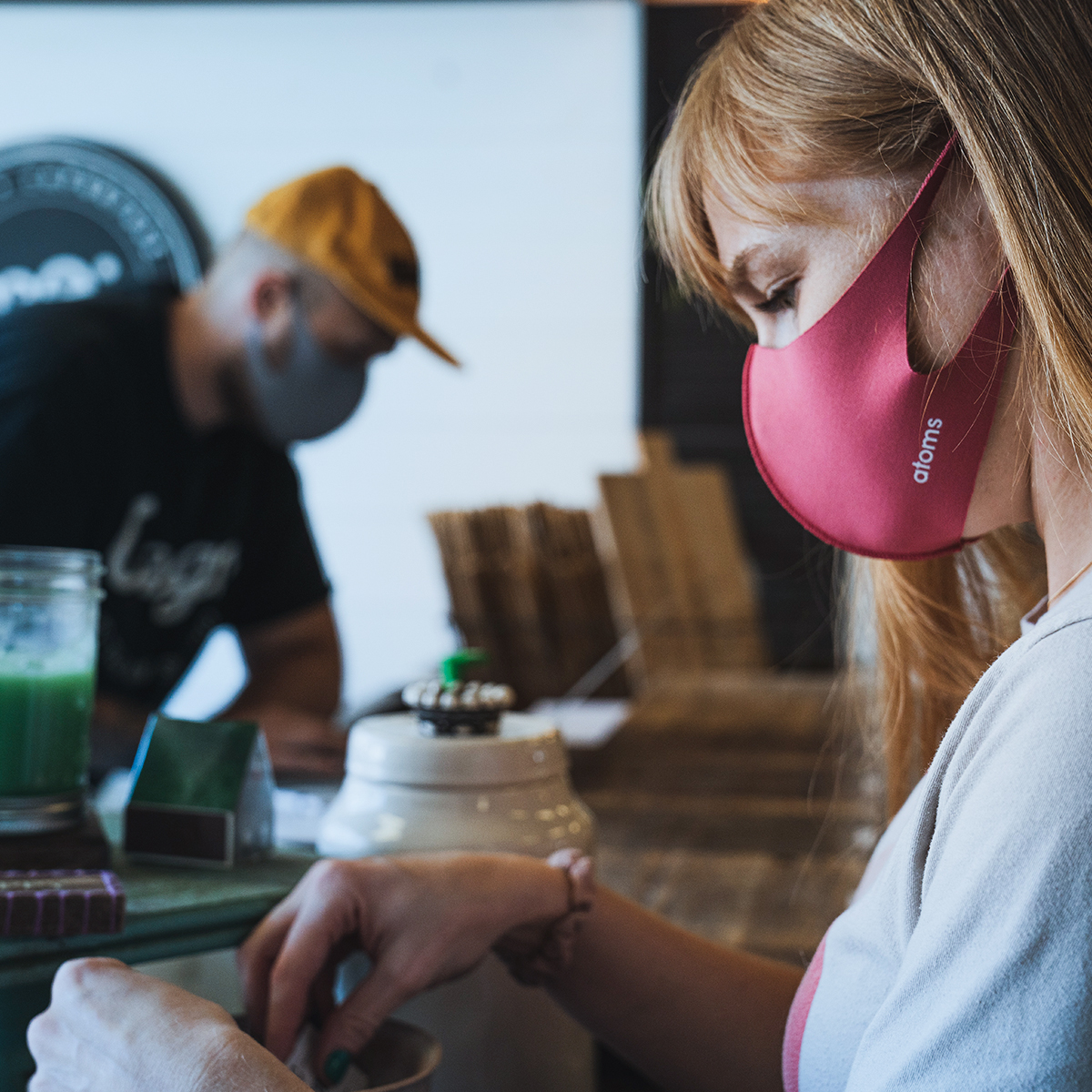 Frau mit Atemschutzmaske in der Gastronomie