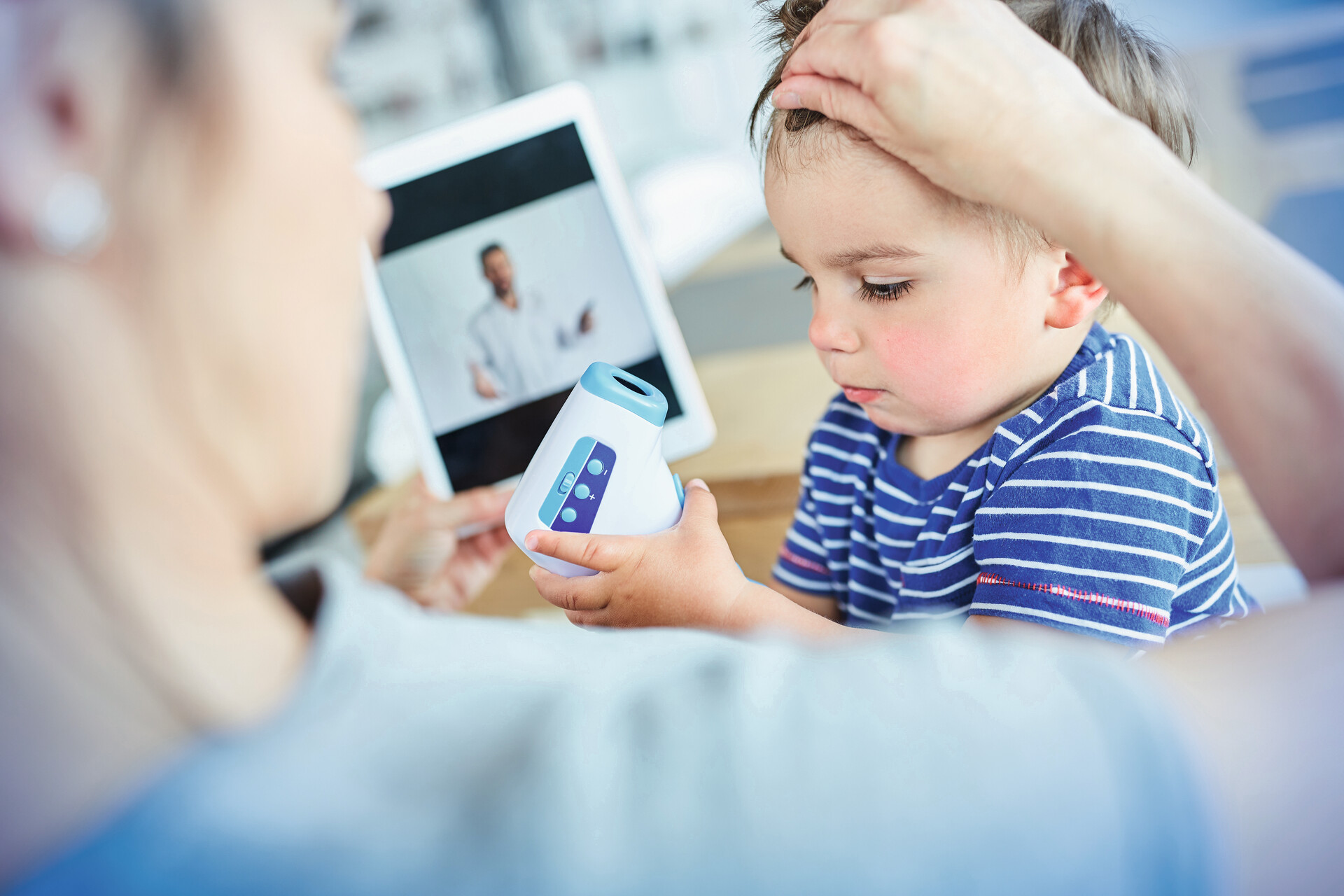 Mutter mit fiebrigem Kind bei Videosprechstunde
