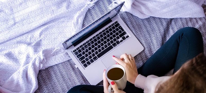 Frau am Laptop mit Kaffetasse