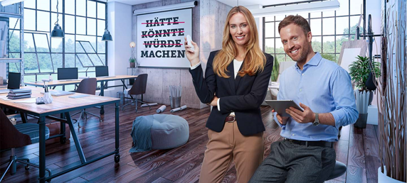 Mann und Frau stehen im Büro und zeigen auf Schild